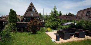 uma casa com um pátio com um guarda-sol e cadeiras em Fichtelgebirgshaus em Fichtelberg