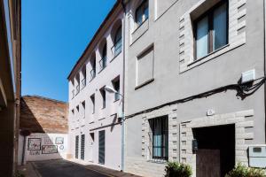 um edifício branco com janelas numa rua em Petit Luxe Tobella Dreta em Terrassa