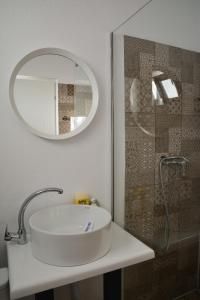 a bathroom sink with a mirror and a shower at The Moon Vama Veche in Vama Veche