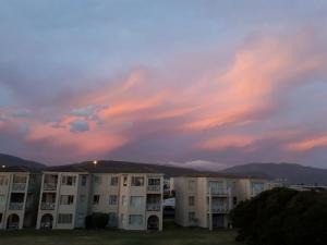 a view of a building with a cloudy sky at Huisi by di C in Hermanus