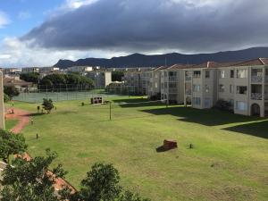 a large grassy area with buildings and a park at Huisi by di C in Hermanus