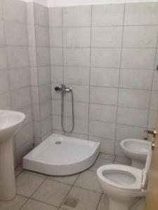 un bagno bianco con un water e un lavandino di Amal Vlora Apartament a Vlorë