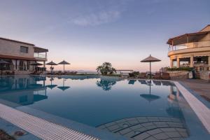 a swimming pool at a resort with a view of the ocean at Blue Bay Halkidiki in Afitos