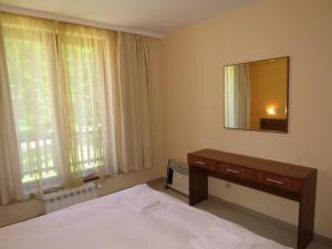 a bedroom with a bed and a dresser and a mirror at Villa Park Apartment nr 216 in Borovets