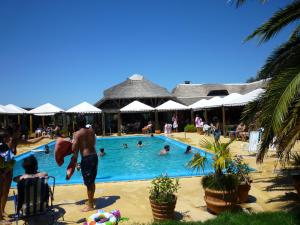 a man standing in the swimming pool at a resort at Pueblo Chico Agroturismo Hotel in La Floresta