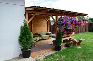 a garden with a pergola with a couch and flowers at Apartman Martin in Martin