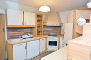 eine Küche mit weißen Geräten und Holzschränken in der Unterkunft Ferienwohnung und Gästezimmer Gaspar in Halbenrain