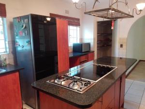 a kitchen with a stove and a refrigerator at Fourways Guest Lodge in Johannesburg