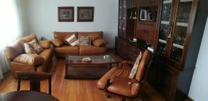 a living room with leather couches and a table at O Parque in Arzúa