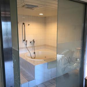 eine Badewanne mit Dusche im Bad in der Unterkunft The Moon Hotel in Taipeh