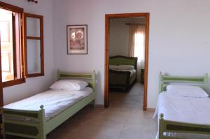 1 dormitorio con 2 camas y espejo en Old Winery House en Kolymvari