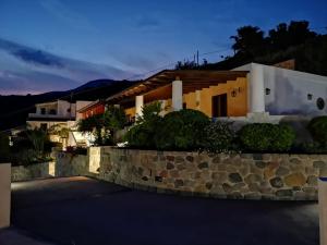 una villa con un muro in pietra di fronte a una casa di Case Vacanze Valle a Città di Lipari