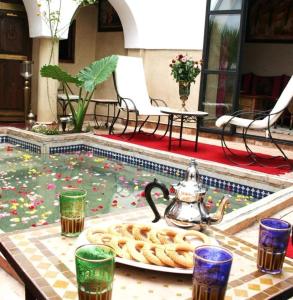 un tavolo con vassoio di pretzel e un bollitore per il tè di Dar Narjis a Marrakech