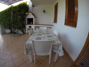 tavolo e sedie bianchi in cucina con tavolo e sedie a sdraio di Villetta indipendente - Torre dell' Orso a Torre dell'Orso