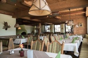 a dining room with white tables and chairs at Hotel Räucherhansl in Loiching