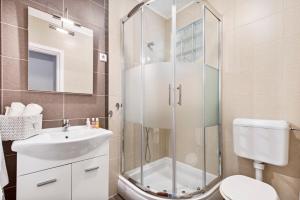 a bathroom with a shower and a sink and a toilet at Apartman Ivan in Malinska +22 photos