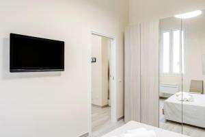 Camera bianca con TV a schermo piatto a parete di Bari Centrale Railway Station Apartment a Bari