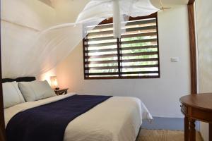 A bed or beds in a room at Whispering Palms - Absolute Beachfront Villas