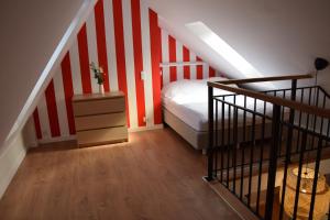 a bedroom with a staircase with red and white stripes at VerrAri Apartaments in Łeba