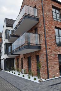 a brick building with a balcony on it at VerrAri Apartaments in Łeba