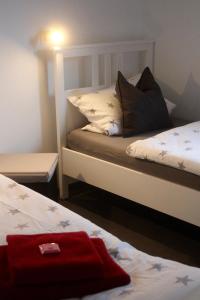 1 dormitorio con 2 camas y toalla roja en Eifel Apartments, en Esch