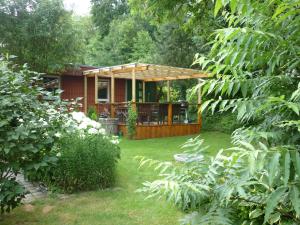 a small red house with a deck in a yard at Haus am Sandsteinbruch in Zaberfeld