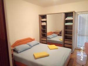 sypialnia z 2 łóżkami i lustrem w obiekcie Apartman CENTAR w Barze
