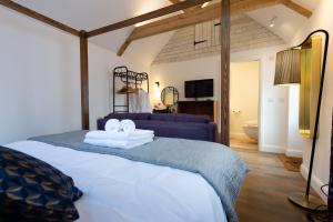1 dormitorio con 1 cama con 2 toallas en The Withies Inn en Godalming
