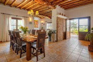 cocina y comedor con mesa y sillas en Villa Curreu III en Santa Gertrudis de Fruitera