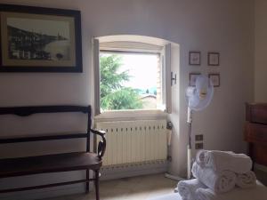 聖費利切德爾貝納科的住宿－Alboino Apartments - Ermengarda & Desiderata，卧室设有窗户、椅子和风扇