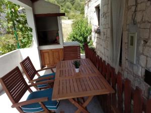 a wooden table and chairs on a patio at Apartman" Afrodita" in Biševo