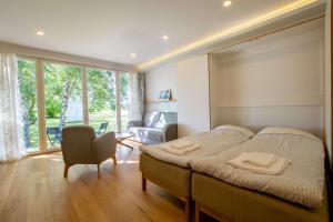 ein Schlafzimmer mit einem Bett, einem Stuhl und einem Sofa in der Unterkunft Modern Sea View Apartments by Villa Kuus Sõlme in Kuressaare