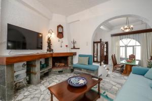a living room with a fireplace and a tv at Naxos Center Houses in Naxos Chora