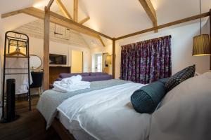 Un dormitorio con una cama grande con toallas. en The Withies Inn, en Godalming