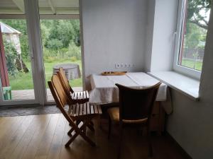 克雷廷加的住宿－River Side Studio, 9mi from Palanga, With sauna，一间带桌椅和窗户的用餐室