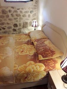 łóżko z żółtymi kwiatami w pokoju w obiekcie Apartments Ana w Kotorze