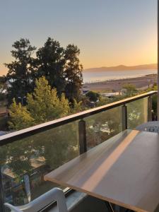 a table and chairs on a balcony with a view of the ocean at GÜMÜLDÜR ÇALIŞKAN APART 1 in Gumuldur