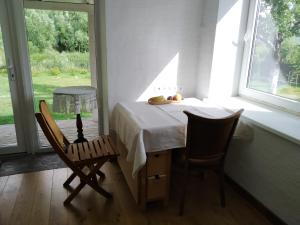 a table and two chairs in a room with a window at River Side Studio, 9mi from Palanga, With sauna in Kretinga