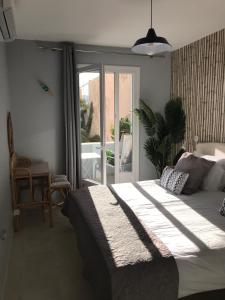 ein Schlafzimmer mit einem großen Bett und einer Glasschiebetür in der Unterkunft Appartement plein centre Saint Florent face au port in Saint-Florent