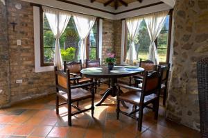 ein Esszimmer mit Tisch und Stühlen und Fenstern in der Unterkunft Casa de las Palmas in Villa de Leyva + 23 Fotos