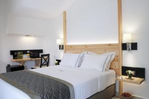 a bedroom with a large white bed and a desk at Acrotel Elea Beach in Elia