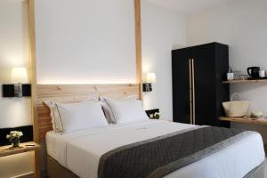 a bedroom with a large bed with white sheets and pillows at Acrotel Elea Beach in Elia
