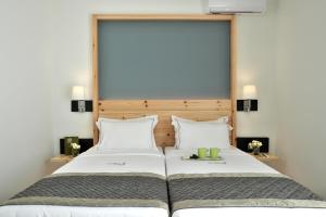 a bedroom with a large bed with two white pillows at Acrotel Elea Beach in Elia