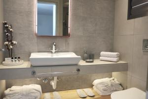 a bathroom with a sink and a mirror and towels at Acrotel Elea Beach in Elia
