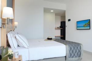 a bedroom with a bed and a tv on a wall at Acrotel Elea Beach in Elia