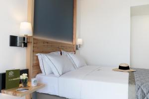 a bedroom with a large white bed and a table at Acrotel Elea Beach in Elia