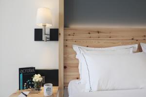 a bedroom with a white bed and a wooden headboard at Acrotel Elea Beach in Elia