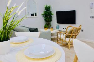 a living room with a table with white plates on it at Gosol Lemon in Sanlúcar de Barrameda