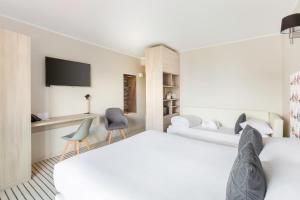 a hotel room with a bed and a tv at Best Western Plus Antibes Riviera in Antibes