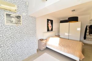 a bedroom with a bed and a brick wall at Ozana apartament in Constanţa